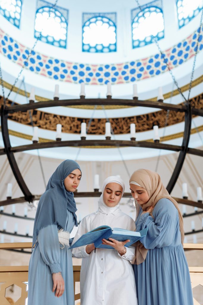 Three women in a mosque read a holy book during Ramadan. Peaceful and spiritual scene. sales leader