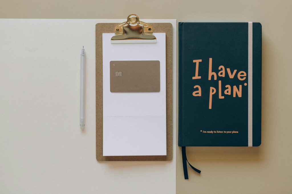 A minimalist office setup featuring a planner, clipboard, card, and pen, perfect for planning and organization. plan. pension plan. persiapan pensiun.
